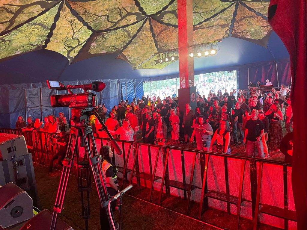 View of audience shrouded in red light at Gay Clail gig, Beautiful Days 2024